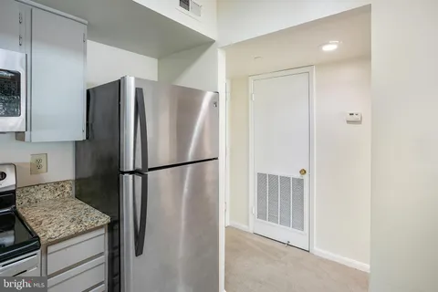 a view of a kitchen with refrigerator and cabinet