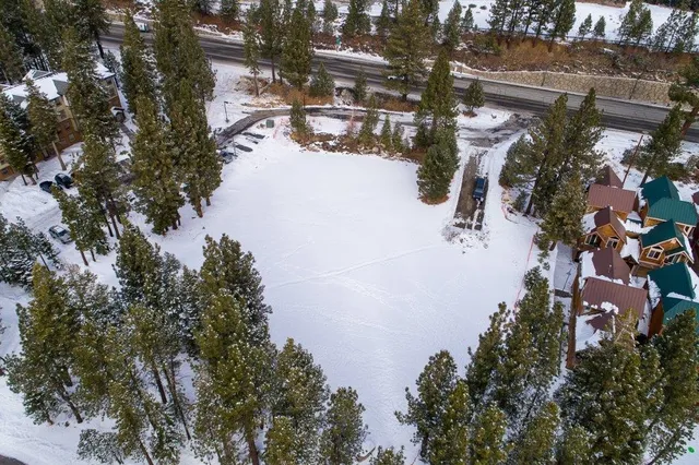 an aerial view of a house yard and mountain view in back