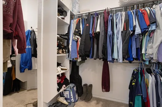 a view of walk in closet with clothes
