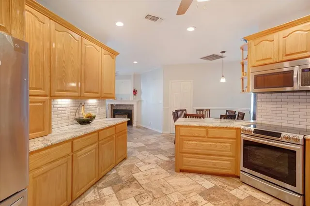 a kitchen with granite countertop cabinets stainless steel appliances and a window
