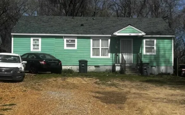 a view of a house with a bed and a table