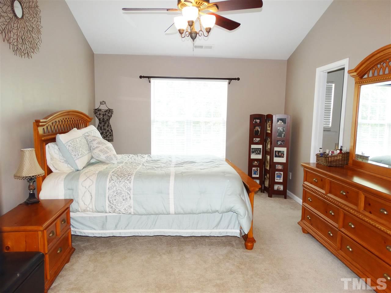 2166 Metacomet Way Raleigh, NC 27604 - Photo 14 of 25 a bedroom with a bed and a chandelier