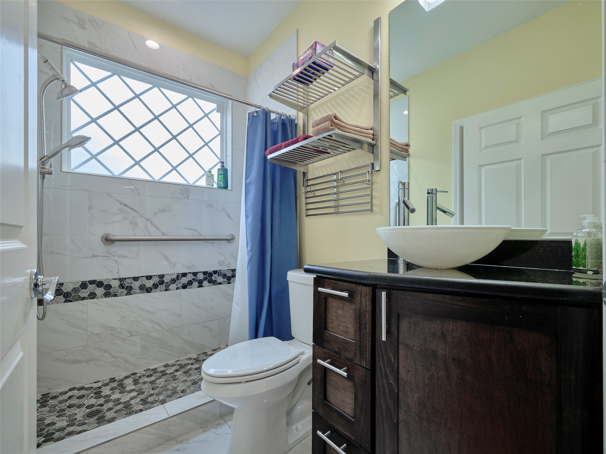 4219 Redbud Street Houston, TX 77051 - Photo 15 of 25 Experience convenience and style with this beautifully designed full bath, perfect for the extra downstairs bedroom, featuring modern fixtures and elegant tilework.