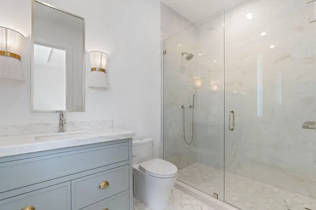 a bathroom with a granite countertop sink toilet a shower and a mirror