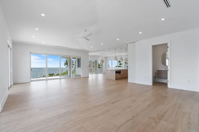 a large kitchen with kitchen island a large counter top stainless steel appliances and a chandelier