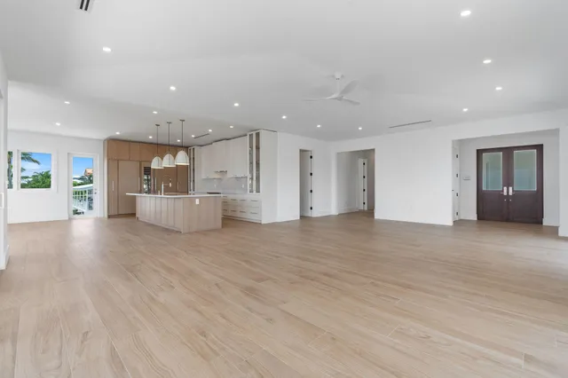 a large kitchen with granite countertop a large counter top stainless steel appliances and wooden floor