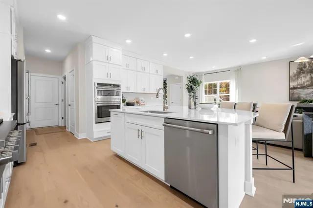 a kitchen with white cabinets and refrigerator