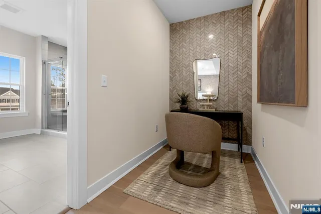 a view of a hallway with wooden floor and a mirror