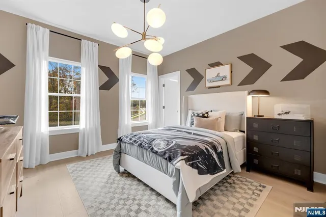 a spacious bedroom with a bed and a chandelier