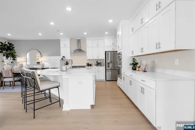 a kitchen with white cabinets and refrigerator