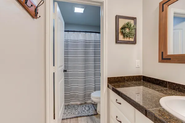 a bathroom with a granite countertop sink and a mirror
