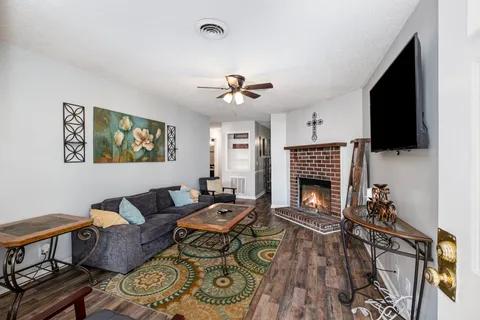 a living room with furniture a flat screen tv and a fireplace