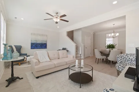 a living room with furniture and a chandelier