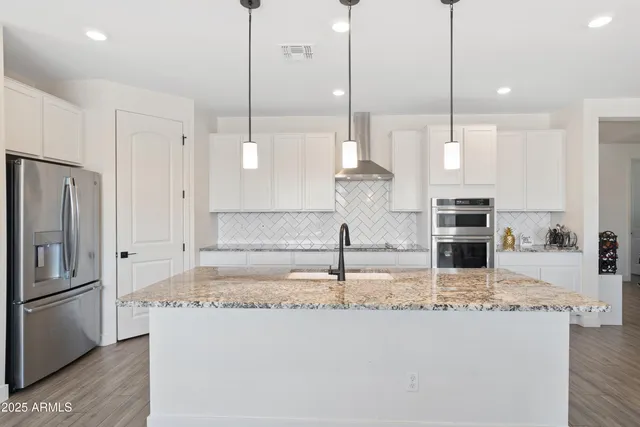 a kitchen with kitchen island granite countertop a sink a center island and stainless steel appliances