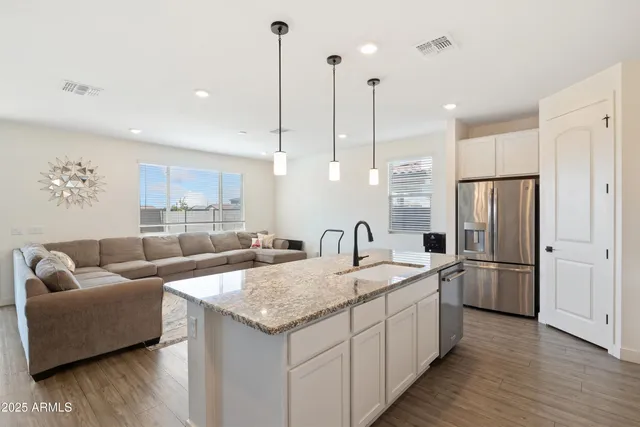 a kitchen with stainless steel appliances granite countertop a sink refrigerator and cabinets