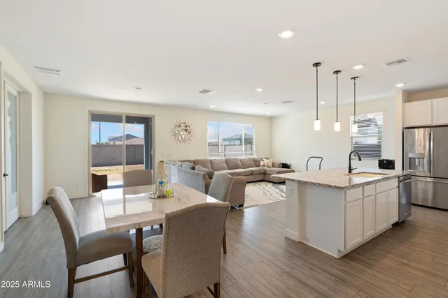 a kitchen with a refrigerator a sink and wooden floor