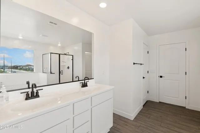 a bathroom with a double vanity sink a mirror and a bathtub