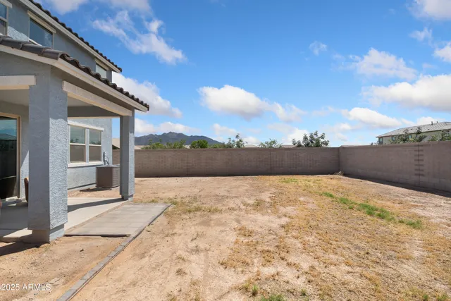 a bedroom with a bed couches chair and a large window