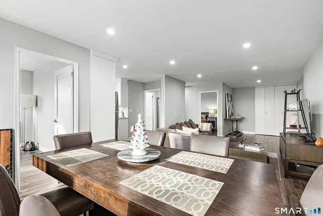 a view of a dining room and livingroom with furniture wooden floor a rug and a chandelier