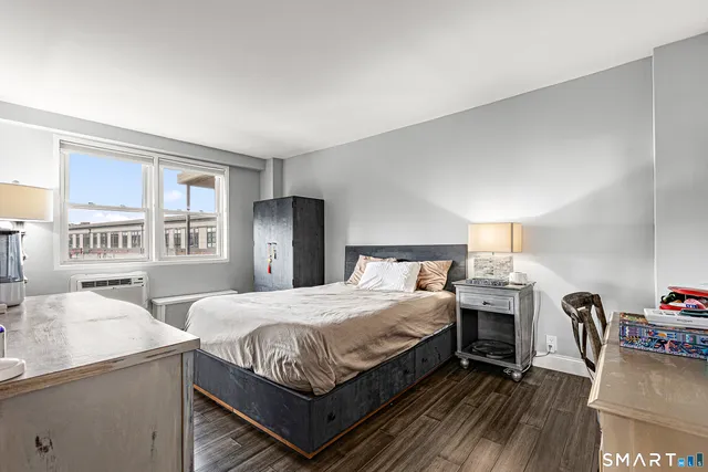 a bedroom with a bed and a dresser next to a window