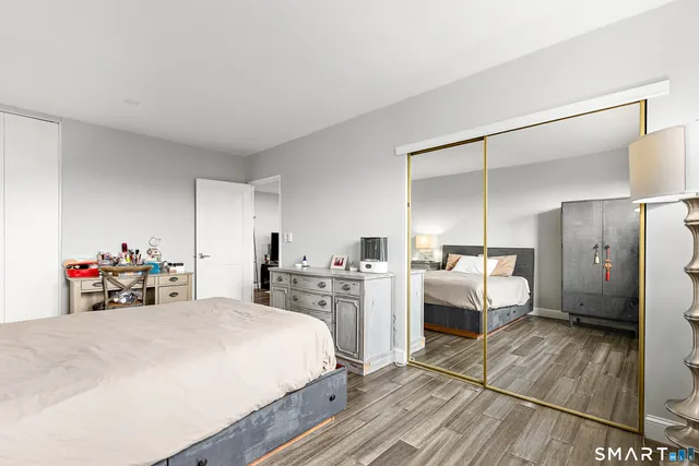 a bedroom with a bed and a large mirror on the dresser