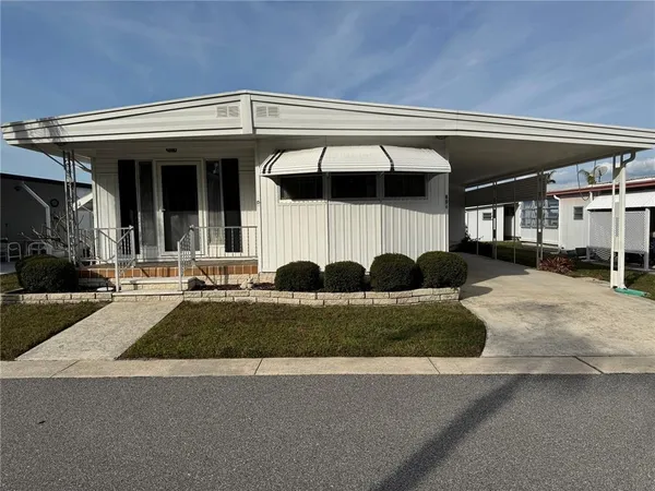 a front view of a house with a yard and outdoor seating