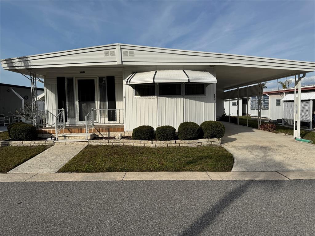 a front view of a house with a yard and outdoor seating