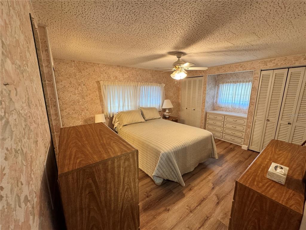 2331 Belleair Road, Unit 804 Clearwater, FL 33764 - Photo 15 of 37 a spacious bedroom with a bed and a chandelier