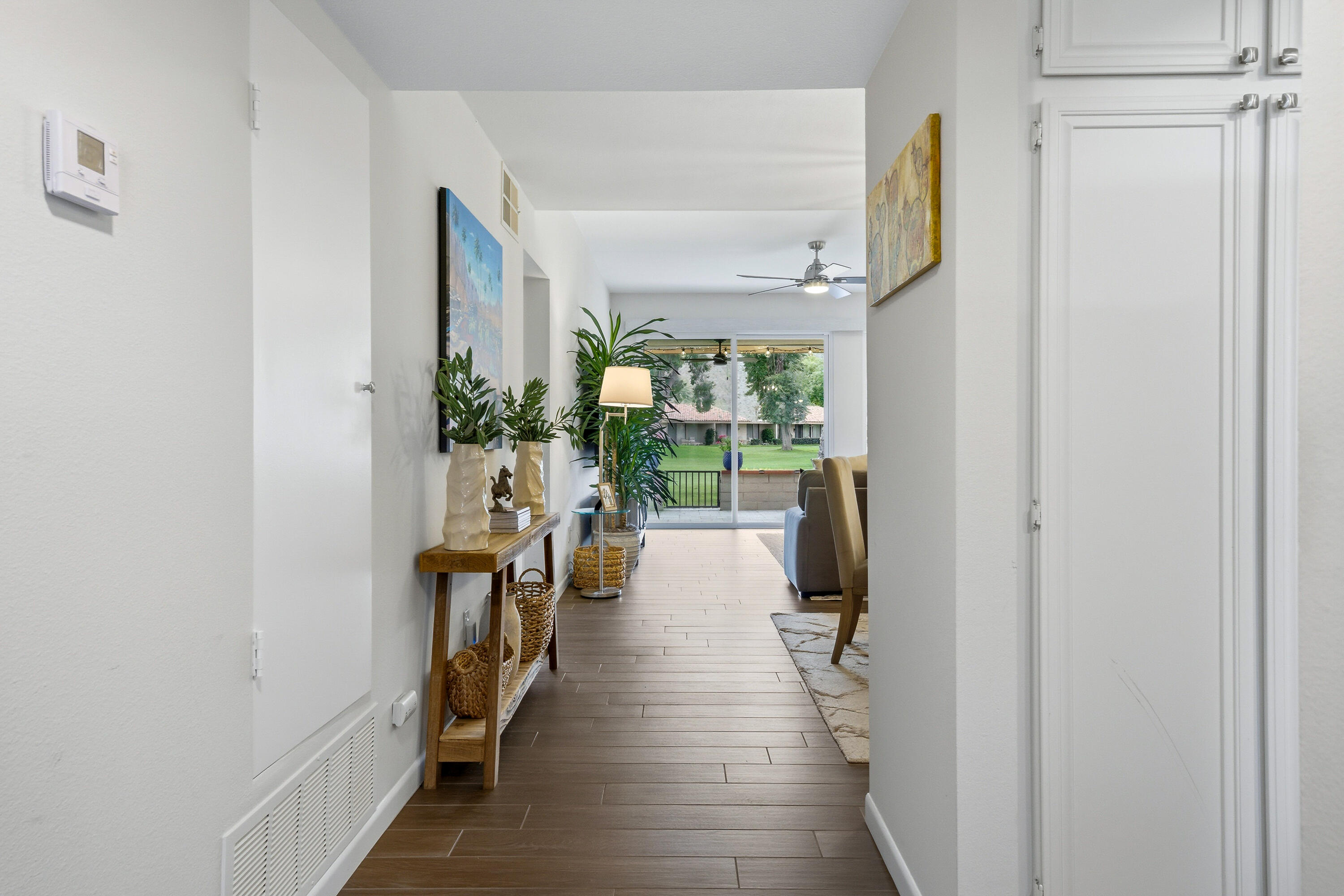24 Palma Drive Rancho Mirage, CA 92270 - Photo 7 of 40 a hallway with a wooden floor and a living room