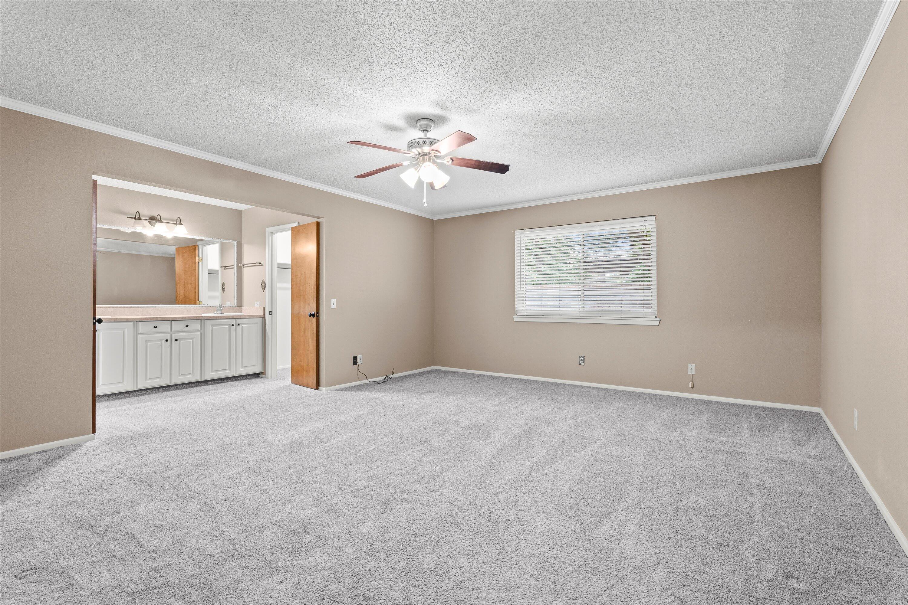 103 Baylor Lane Levelland, TX 79336 - Photo 11 of 27 an empty room with chandelier fan and windows