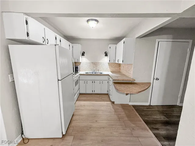 a kitchen with a refrigerator a sink and cabinets