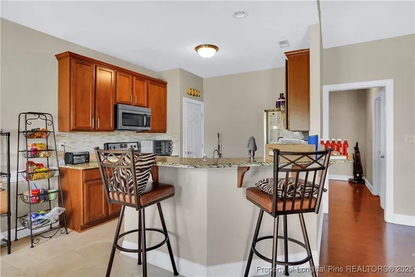 a kitchen with stainless steel appliances wooden cabinets and a stove top oven