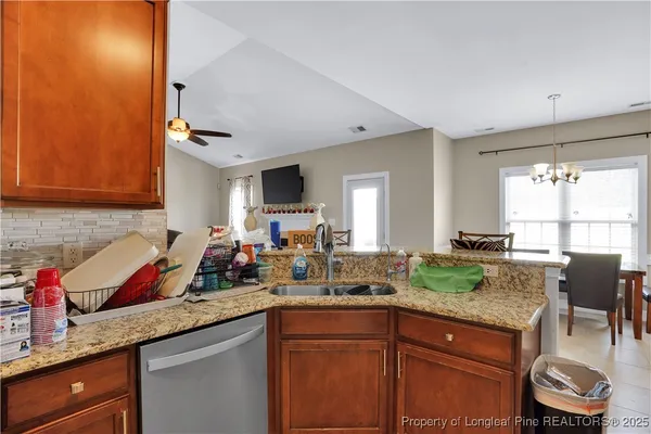 a kitchen with granite countertop a sink stove and cabinets