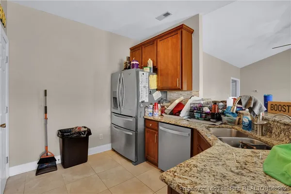 a kitchen with stainless steel appliances granite countertop a sink dishwasher stove and refrigerator
