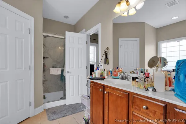a bathroom with a double vanity sink mirror and shower