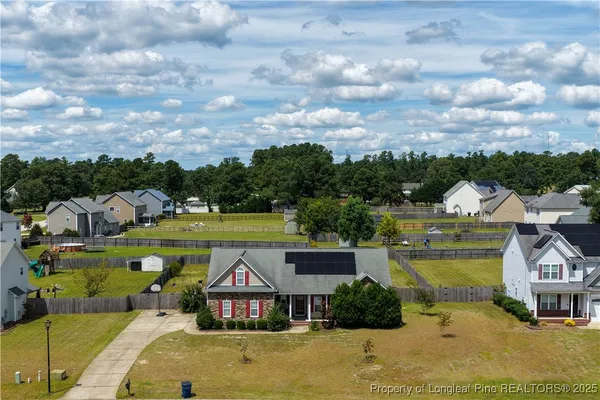 a view of a house with a big yard and large trees