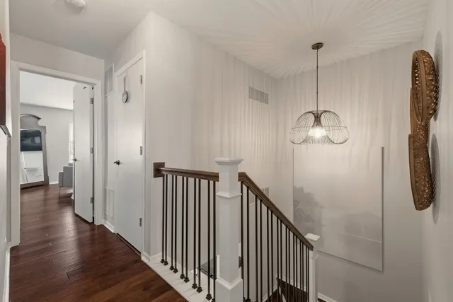 a view of a hallway with wooden floor and staircase