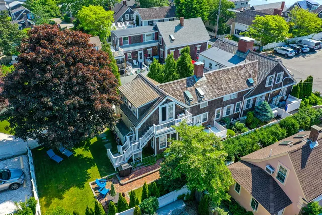 an aerial view of multiple houses with a yard