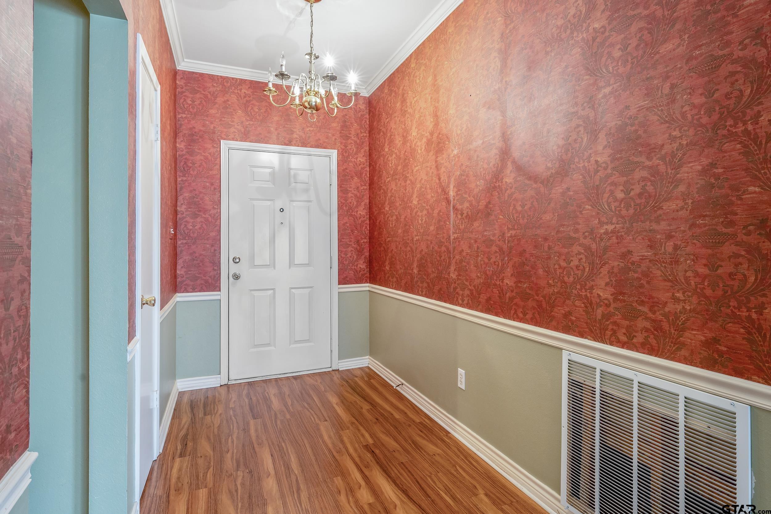 1202 Rice Road, Unit 135 Tyler, TX 75703 - Photo 3 of 21 a view of a hallway with wooden floor and chandelier