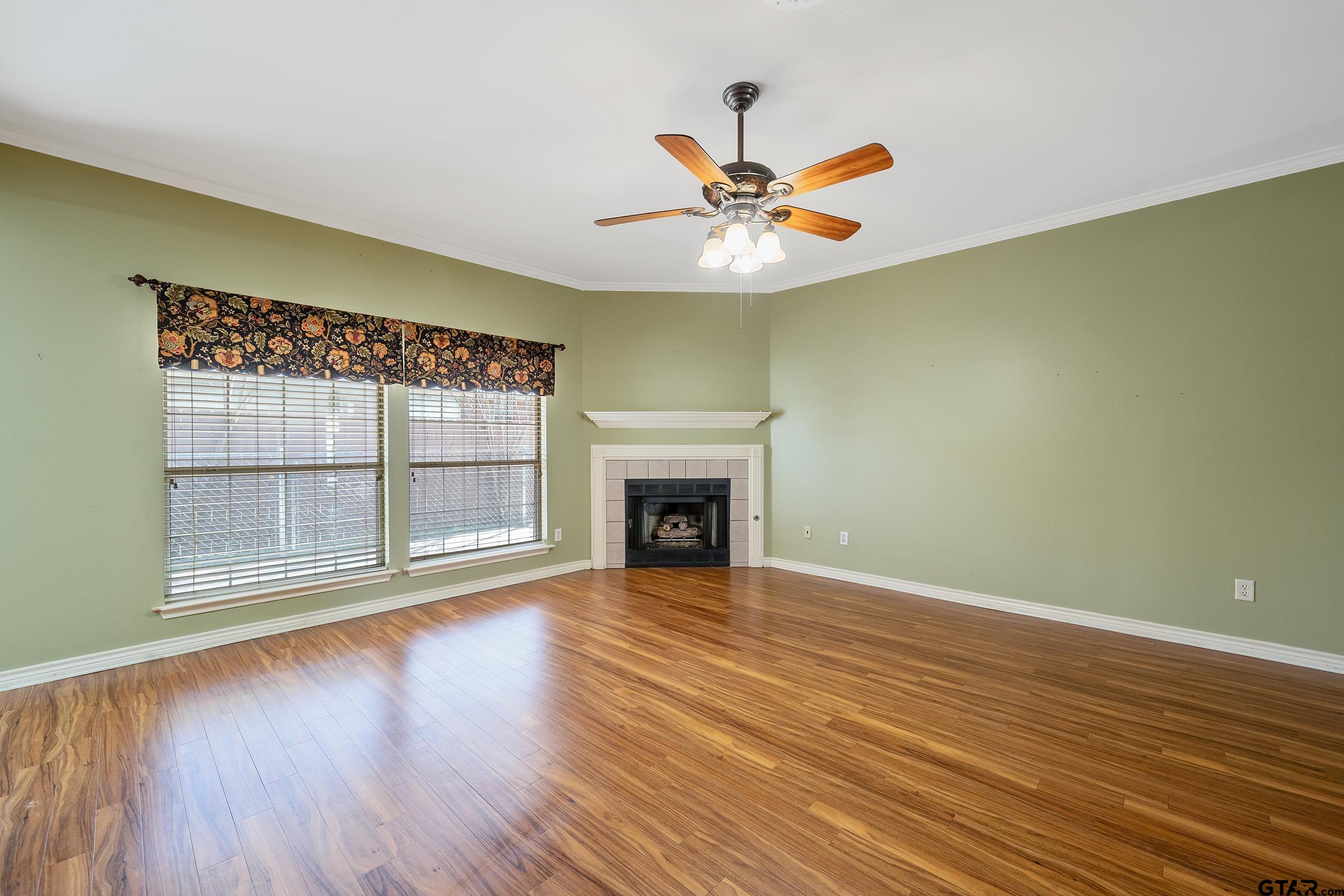 1202 Rice Road, Unit 135 Tyler, TX 75703 - Photo 4 of 21 a view of an empty room with wooden floor and a window