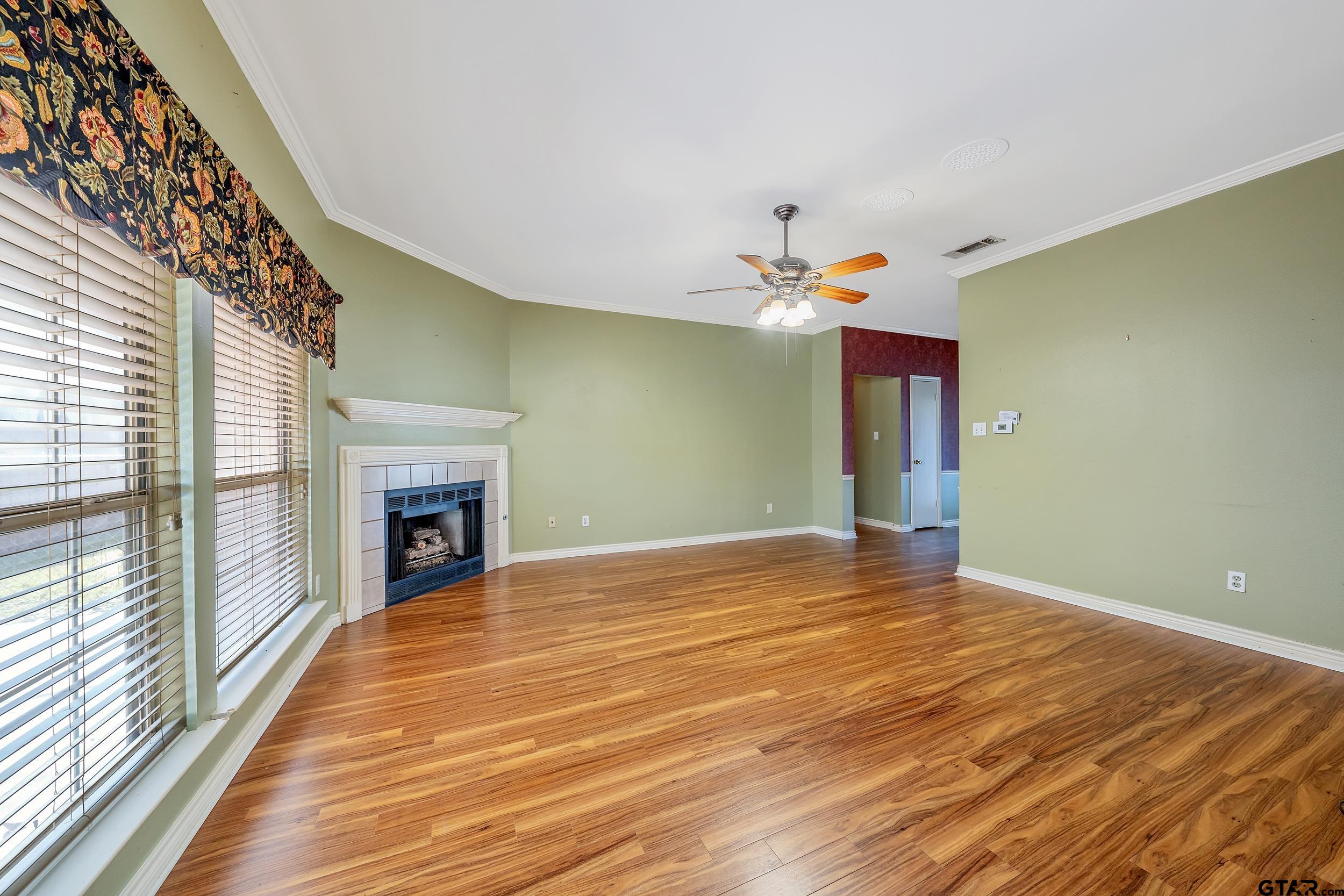 1202 Rice Road, Unit 135 Tyler, TX 75703 - Photo 6 of 21 a view of an empty room with wooden floor and a window