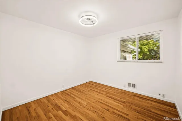 a view of a room with wooden floor and a window