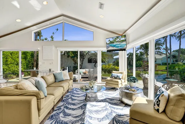 a living room with furniture fireplace and large windows