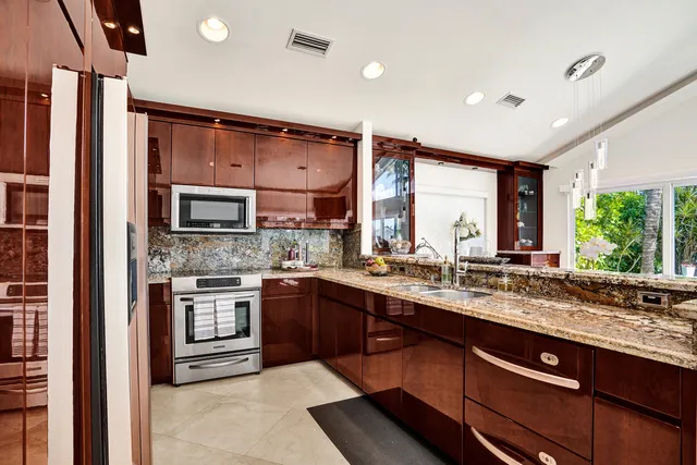 a kitchen with stainless steel appliances granite countertop a sink and stove top oven