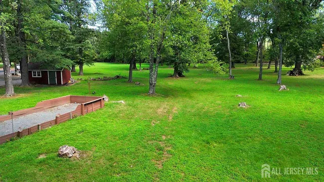 a view of a park with trees and wooden fence