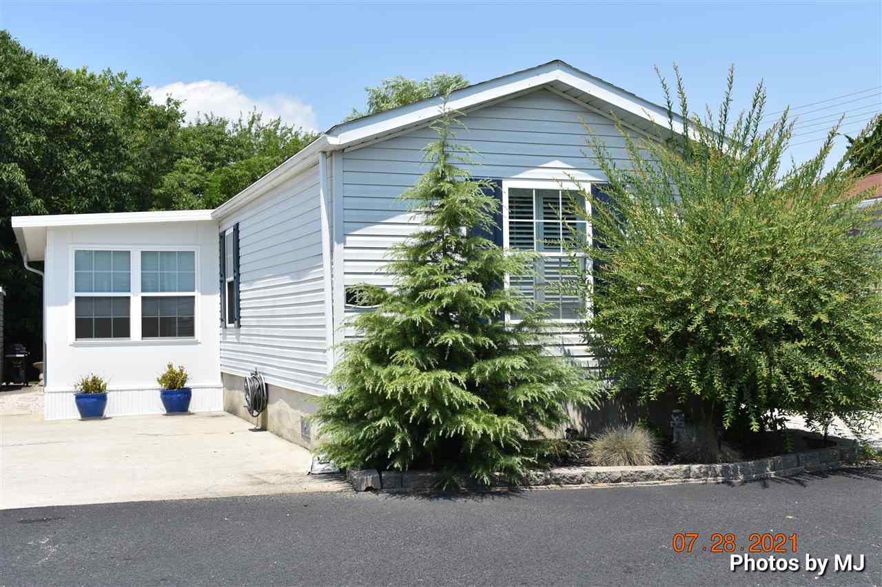 a front view of a house with a yard and potted plants