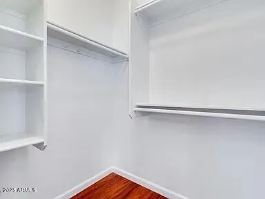 a view of walk in closet with empty racks