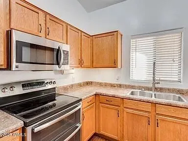 a kitchen with stainless steel appliances a stove microwave and sink
