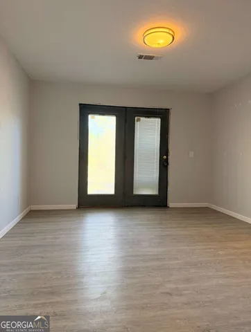 a view of a kitchen with wooden floor and a window