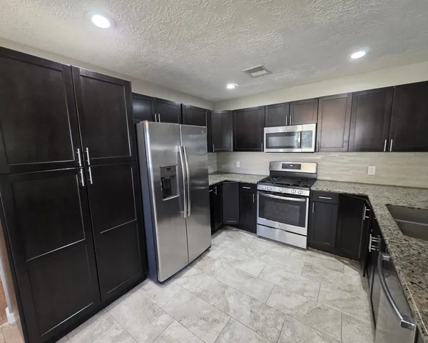 a kitchen with stainless steel appliances a refrigerator and a sink